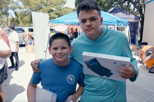 Two students with Florida Connect tablets at an outdoor event.